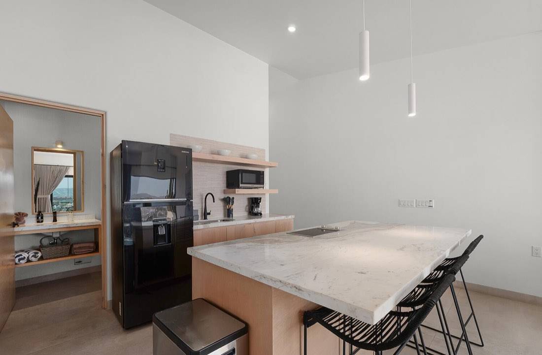 Full kitchen with marble island, refrigerator, and bar seating