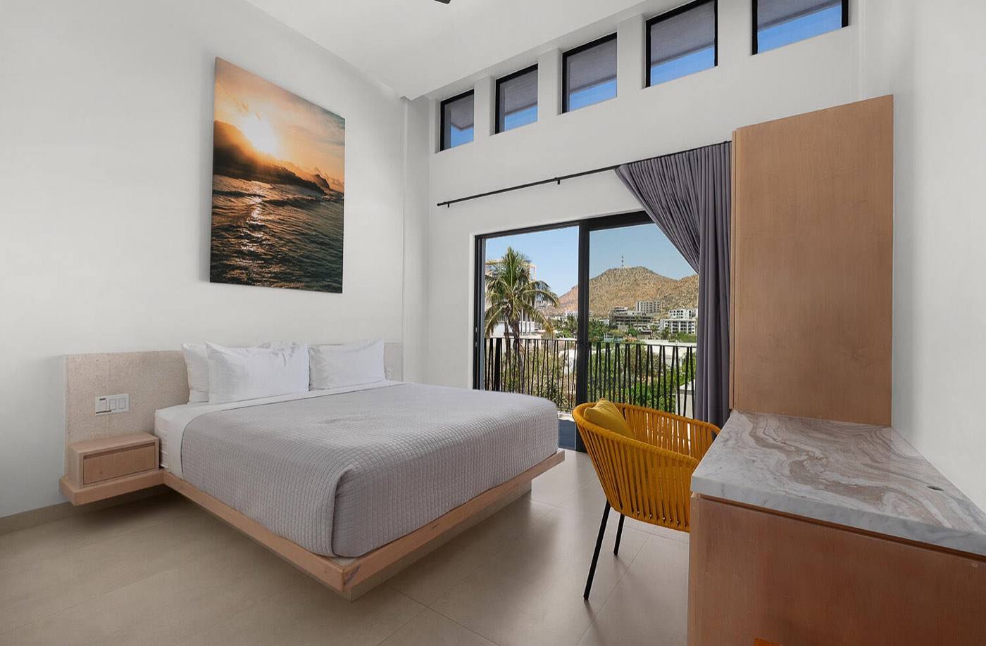 Penthouse bedroom with king bed and double-height windows