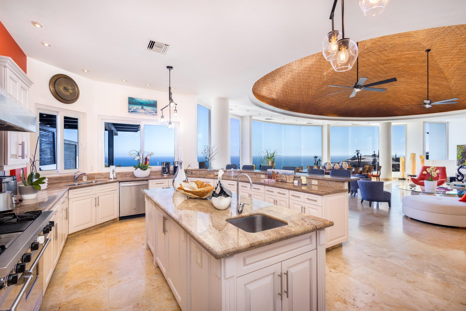 Grand gourmet kitchen with marble island, panoramic ocean views, dramatic curved wood ceiling