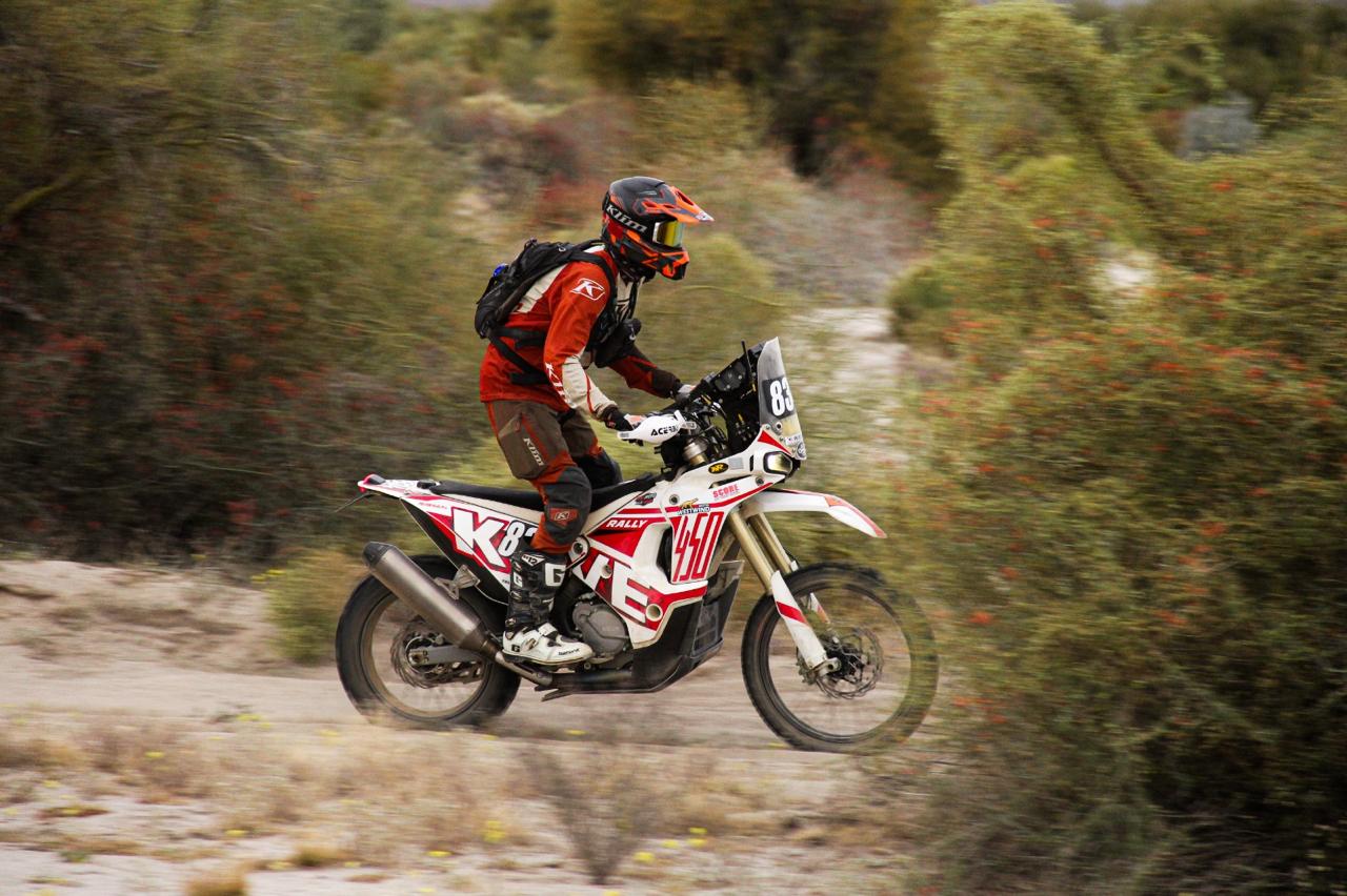 Scott Purcell racing his Kove 450 Rally Pro through Baja scrubland, slightly airborne with motion blur